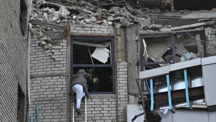 Um socorrista evacua uma mulher de um prédio fortemente danificado por um ataque de míssil russo, em meio ao ataque da Rússia à Ucrânia, em Zaporizhzhia, Ucrânia, em 10 de dezembro de 2024. REUTERS/Stringer