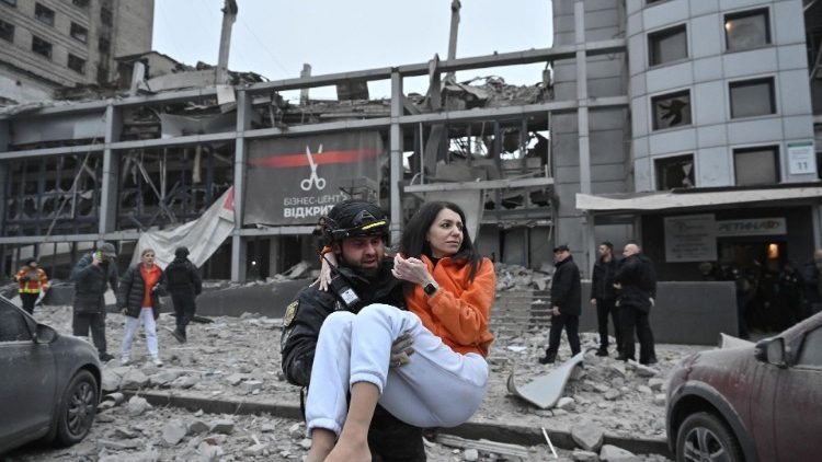 Um policial evacua uma mulher de um prédio fortemente danificado por um ataque de míssil russo, em meio ao ataque da Rússia à Ucrânia, em Zaporizhzhia, Ucrânia, em 10 de dezembro de 2024. REUTERS/Stringer TPX IMAGENS DO DIA