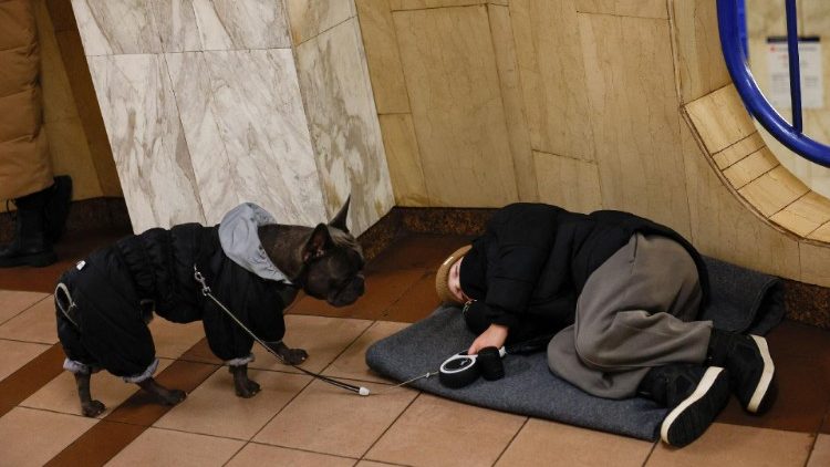 Um homem dorme ao lado de seu cachorro enquanto as pessoas se abrigam dentro de uma estação de metrô durante um ataque militar russo, em meio ao ataque da Rússia à Ucrânia, em Kiev, Ucrânia, 13 de dezembro de 2024. REUTERS/Alina Smutko