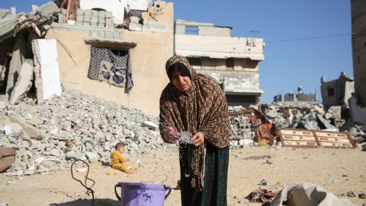 Mwanamke wa Kipalestina aliyefukuzwa makazi,anatumia maji nje ya makazi yake,huko Khan Younis.