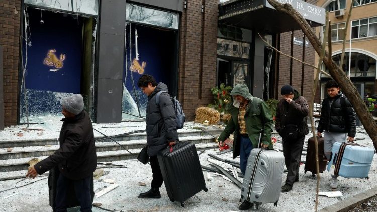 Moradores saem com seus pertences do local de um ataque de míssil russo, em meio ao ataque da Rússia à Ucrânia, no centro de Kiev, Ucrânia, em 20 de dezembro de 2024. REUTERS/Thomas Peter
