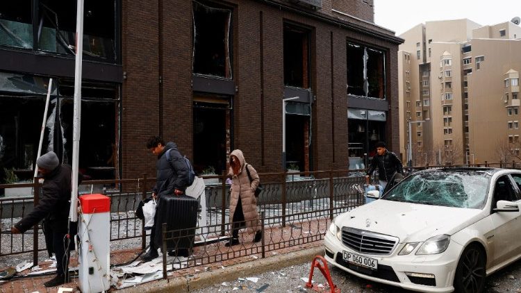People walk near a damaged building after a Russian missile strike, amid Russia's attack on Ukraine, in central Kyiv, Ukraine, December 20, 2024. REUTERS/Valentyn Ogirenko
