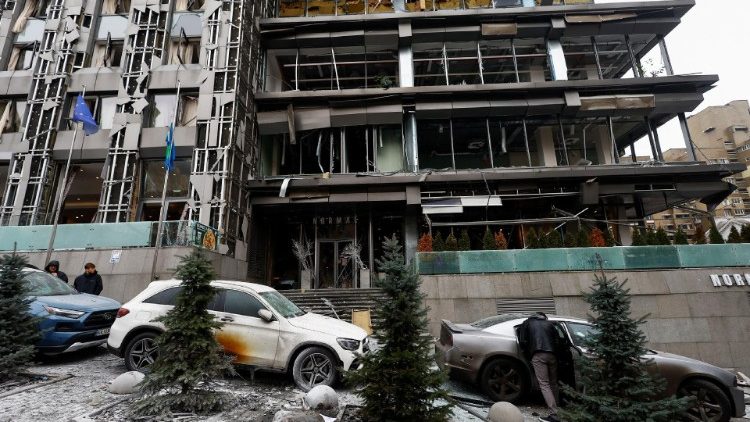 Uma pessoa verifica um carro parado perto de um prédio danificado durante um ataque de míssil russo, em meio ao ataque da Rússia à Ucrânia, no centro de Kiev, Ucrânia, em 20 de dezembro de 2024. REUTERS/Valentyn Ogirenko