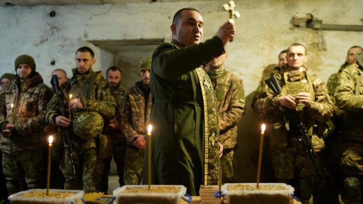 Um capelão militar ortodoxo conduz uma missa de véspera de Natal para militares da 72ª Brigada Mecanizada Separada Chorni Zaporozhtsi das Forças Armadas Ucranianas, em meio ao ataque da Rússia à Ucrânia, em uma posição na linha de frente na região de Donetsk, Ucrânia, em 24 de dezembro de 2024.