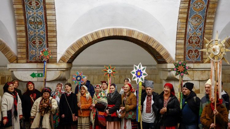 Pessoas vestidas com roupas tradicionais cantam canções de natal dentro de uma estação de metrô durante a celebração de Natal, em meio ao ataque da Rússia à Ucrânia, em Kiev, Ucrânia, 25 de dezembro de 2024. REUTERS/Valentyn Ogirenko