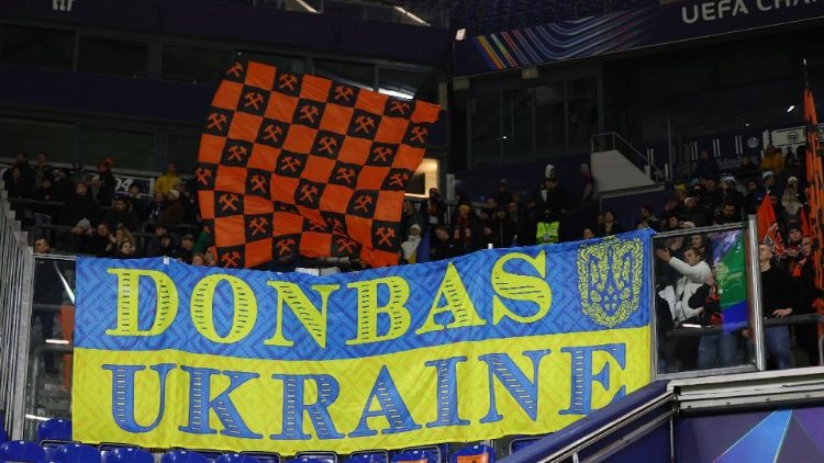  Liga dos Campeões - Shakhtar Donetsk x Brest - Veltins Arena, Gelsenkirchen, Alemanha - 22 de janeiro de 2025 Torcedores com uma bandeira da Ucrânia com os dizeres "Donbass Ucrânia" nas arquibancadas REUTERS/Wolfgang Rattay