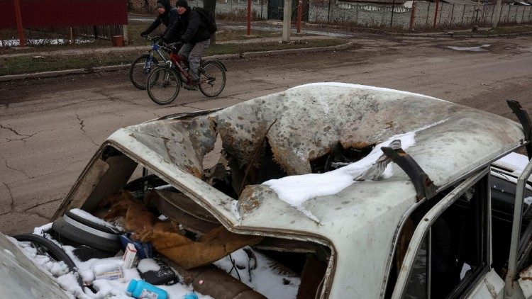 Moradores andam de bicicleta perto de um carro destruído por ataques militares russos, em meio ao ataque da Rússia à Ucrânia, em Pokrovsk, região de Donetsk, Ucrânia, 6 de fevereiro de 2025. REUTERS/Anatolii Stepanov