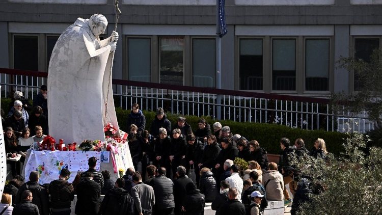 Numerosi fedeli sotto la statua di Giovanni Paolo II al Policlinico Gemelli