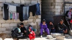 Syrians who fled the violence in western Syria, sit together in Akkar, after the reported mass killings of Alawites