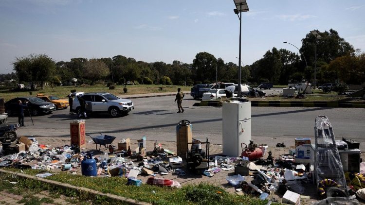 Security personnel stand at a checkpoint and confiscate stolen items, in Latakia