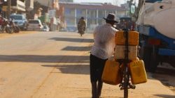 A man pushes his bicycle with fuel jerrycans along a street in Juba