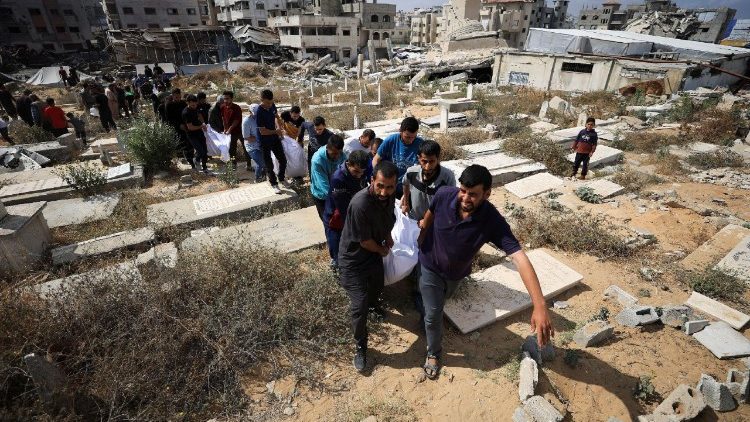Mourners carry the bodies of members of the Al-Arabeed family killed in Israeli strikes, at a cemetery, in Gaza City