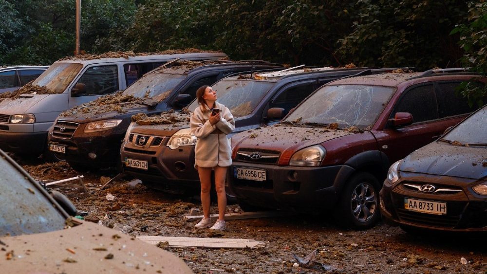 Uma moradora perto de veículos danificados após ataques russos, em meio ao ataque russo à Ucrânia, em Kiev, Ucrânia, em 17 de junho de 2025. REUTERS/Valentyn Ogirenko