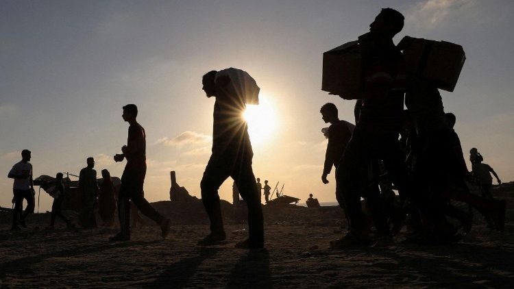 Palestinesi trasportano aiuti umanitari a Beit Lahia, nord di Gaza (Reuters)