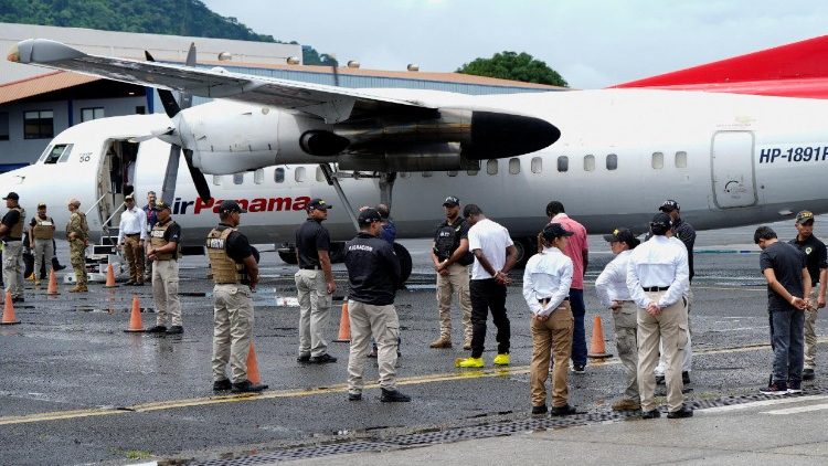 Migranti colombiani tra le guardie vicino a un volo di deportazione diretto a Medellin, Colombia 