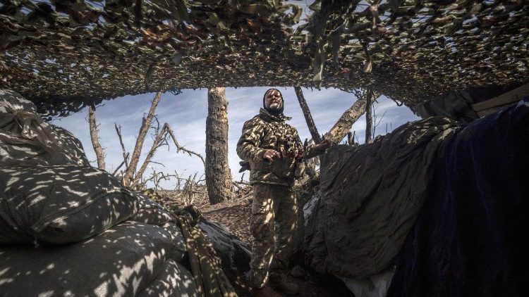 Infantry soldier Viktor of Ukraine's 58th Motorized Brigade scans the sky for drones as he stands in a frontline trench in the Donetsk region