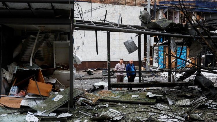 Pessoas observam um ponto de ônibus danificado do lado de fora da estação de metrô, que foi danificada durante a noite devido a ataques de drones e mísseis russos, em meio ao ataque da Rússia à Ucrânia, em Kiev, Ucrânia, em 21 de julho de 2025. REUTERS/Thomas Peter