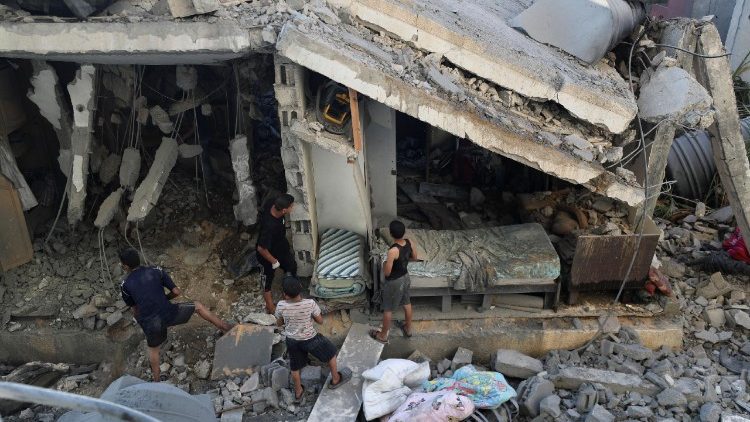 Palestinians inspect the site of an overnight Israeli air strike on a house in Gaza City