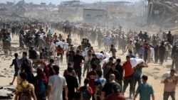 FILE PHOTO: Palestinians gather to receive aid supplies amid a hunger crisis, in Beit Lahia