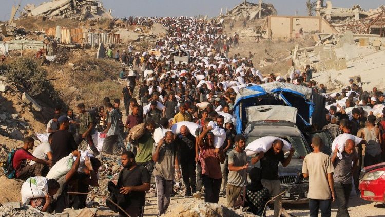 Palestinos transportan ayuda humanitaria que entró en Gaza a través de Israel a Beit Lahia, en el norte de la Franja