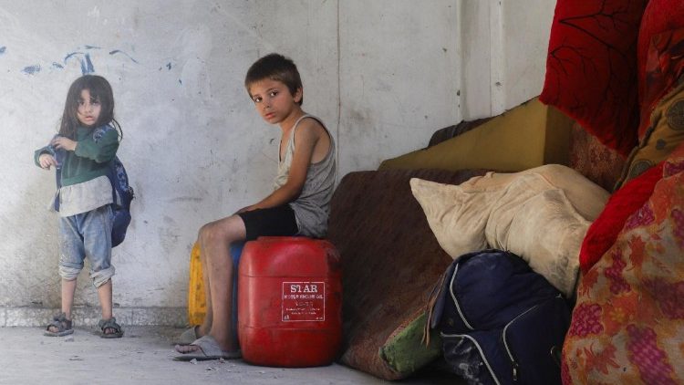 हमले के बाद क्षतिग्रस्त घर से दूसरे जगह समान ले जाते गजा के लोग