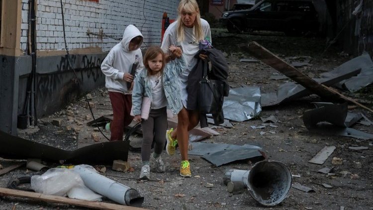Moradores caminham no local de um prédio de apartamentos atingido por ataques de drones e mísseis russos, em meio ao ataque russo à Ucrânia, em Kiev, Ucrânia, em 28 de agosto de 2025. REUTERS/Stringer