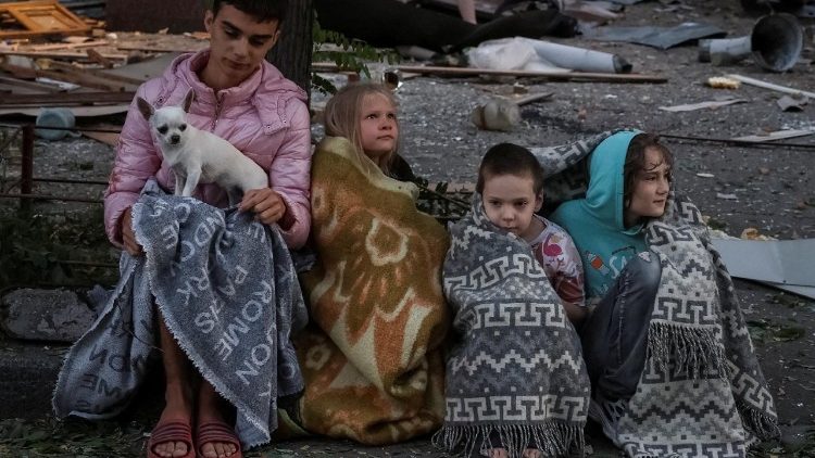 Moradores sentam-se no local de um prédio de apartamentos atingido por ataques de drones e mísseis russos, em meio ao ataque da Rússia à Ucrânia, em Kiev, Ucrânia, em 28 de agosto de 2025. REUTERS/Stringer