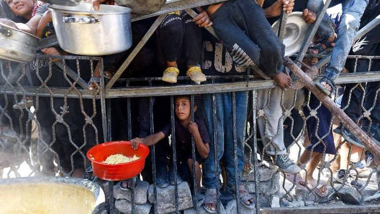 Palestinesi in attesa di ricevere cibo 