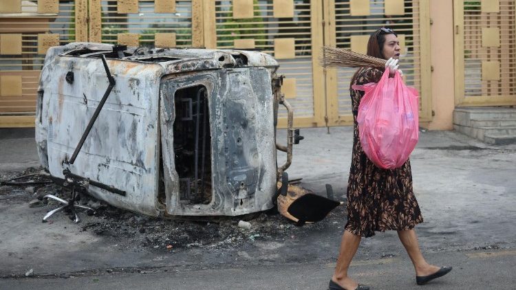 Uma mulher caminha com um saco de lixo perto de um veículo queimado perto do complexo do Parlamento durante o toque de recolher, após o assassinato de 19 pessoas na segunda-feira, após protestos anticorrupção que foram desencadeados por uma proibição de mídia social, que foi posteriormente suspensa, em Katmandu, Nepal, em 10 de setembro de 2025. REUTERS/Adnan Abidi