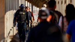 Agentes federais dos EUA escoltam um grupo de migrantes deportados para o México
