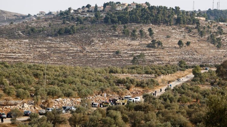 Soldati israeliani controllano i documenti dei palestinesi che raggiungono le loro tere vicino.a Nablus per la raccolta delle olive (Reuters)