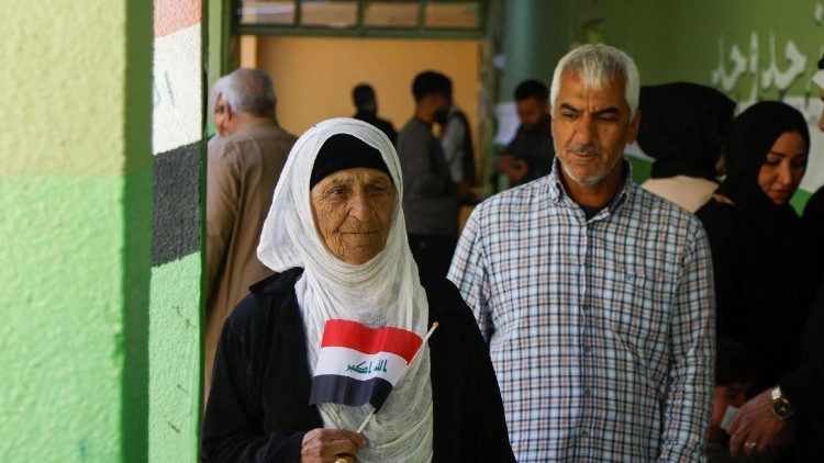  Une femme brandissant un drapeau irakien dans un bureau de vote lors des élections législatives à Mossoul, en Irak, mardi 11 novembre 2025. 