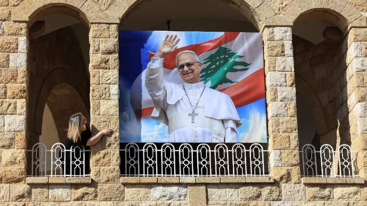 Une femme se tient à côté d'une affiche représentant le pape Léon XIV à l'hôpital psychiatrique De La Croix à Jal el-Dib.