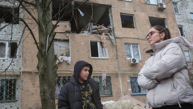 Moradores observam o prédio de apartamentos danificado durante um ataque de drone russo, ocorrido na noite de segunda-feira, em meio ao ataque da Rússia à Ucrânia, na cidade de Kramatorsk, região de Donetsk, Ucrânia, em 2 de dezembro de 2025. REUTERS/Anatolii Stepanov