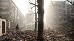 Un militare ucraino cammina vicino a degli edifici residenziali danneggiati da un attacco militare russo nella città di Kostiantynivka