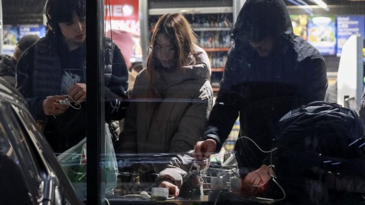 Moradores carregam seus aparelhos eletr&ocirc;nicos em uma loja durante um apag&atilde;o ap&oacute;s infraestruturas civis cr&iacute;ticas terem sido atingidas por recentes ataques russos com m&iacute;sseis e drones, em meio ao ataque da R&uacute;ssia &agrave; Ucr&acirc;nia, em Odessa, Ucr&acirc;nia, 13 de dezembro de 2025. REUTERS/Nina Liashonok