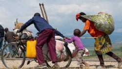 Congolese people displaced during renewed clashes between AFC/M23 and FARDC walk back to their homes from Sange in Luvungi