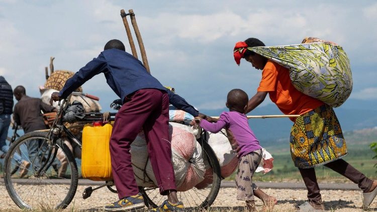 Congolese people displaced during renewed clashes between AFC/M23 and FARDC walk back to their homes from Sange in Luvungi
