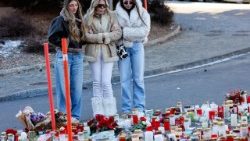 1 जनवरी की रात को लगी आग से मरे लोगों को मोमबत्ती चढ़ाते लोग 