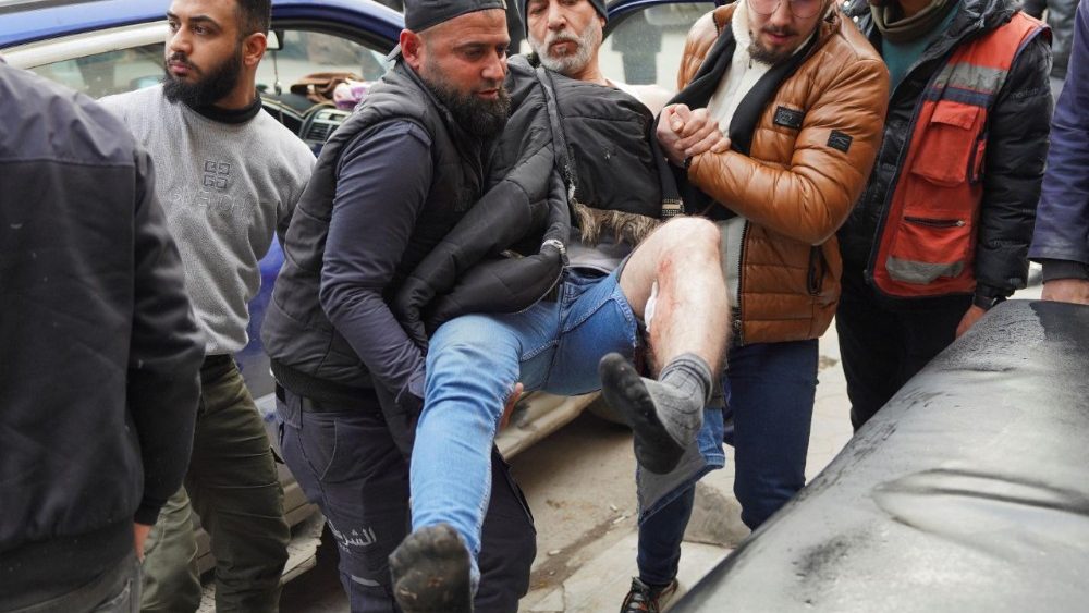 A group of civilians carry a wounded man following renewed clashes between the Syrian army and the Syrian Democratic Force