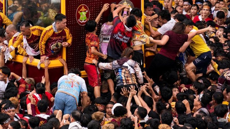 Peregrinos tratan de tocar el carruaje o trepar durante la procesión