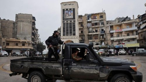 A member of the Syrian army stands on a pick-up truck in Aleppo