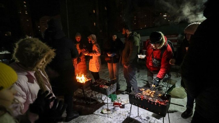 Moradores de um pr&eacute;dio de apartamentos fazem churrasco em um quintal durante um apag&atilde;o ap&oacute;s infraestruturas civis cr&iacute;ticas terem sido atingidas por recentes ataques de m&iacute;sseis e drones russos, em meio ao ataque da R&uacute;ssia &agrave; Ucr&acirc;nia, em Kiev, Ucr&acirc;nia, 18 de janeiro de 2026. REUTERS/Stringer