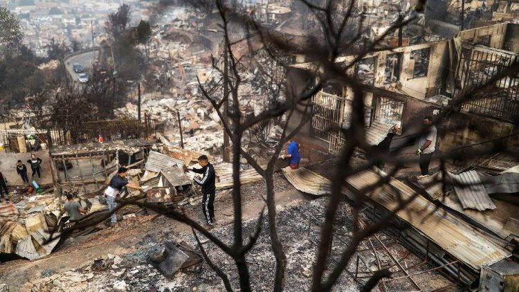 Personas inspeccionan edificios destruidos tras un incendio forestal en la regi&oacute;n del Biob&iacute;o.