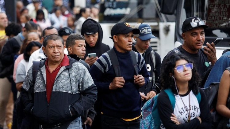 राजधानी काराकस में लोग बस के आन्तजार में 