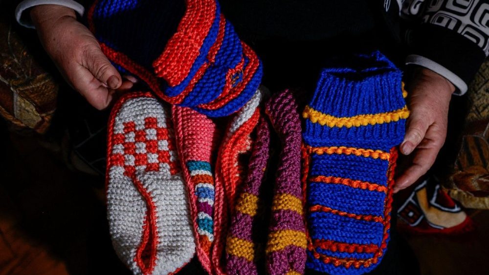 Liubov Klymenko, de 66 anos, mostra meias de lã que tricotou para doar a pessoas que ficaram sem aquecimento em seus apartamentos após infraestruturas civis críticas terem sido atingidas por recentes ataques russos com mísseis e drones, em meio ao ataque da Rússia à Ucrânia, em Kiev, Ucrânia, 23 de janeiro de 2026. REUTERS/Alina Smutko