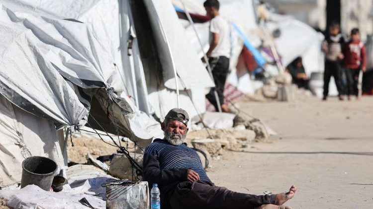 Displaced Palestinian man sits outside his tent in Gaza
