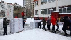 Professores e funcionários levam kits de dormir entregues pela Cruz Vermelha para dentro de um prédio escolar que foi transformado em um ponto de ajuda humanitária, onde as pessoas podem se aquecer, carregar seus dispositivos, tomar bebidas quentes e receber apoio psicológico, durante um apagão após infraestruturas civis críticas terem sido atingidas por recentes ataques de mísseis e drones russos, em meio ao ataque da Rússia à Ucrânia, em Kiev, Ucrânia, 30 de janeiro de 2026. REUTERS/Valentyn Ogirenko