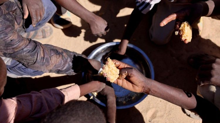Crianças refugiadas sudanesas órfãs de al-Fashir compartilham uma refeição fornecida pelo "Projeto Cozinha Coletiva”.