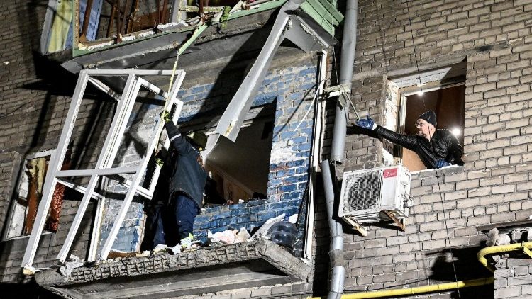 Um socorrista e um morador trabalham no local de um pr&eacute;dio de apartamentos danificado por um ataque de drone russo, em meio ao ataque da R&uacute;ssia &agrave; Ucr&acirc;nia, em Zaporizhzhia, Ucr&acirc;nia, em 24 de fevereiro de 2026. REUTERS/Stringer